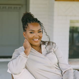 Joi JC Carmichael smiling on a porch